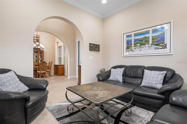 living room featuring light tile patterned floors, baseboards, arched walkways, crown molding, and recessed lighting