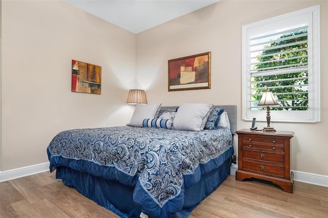 bedroom with wood finished floors and baseboards