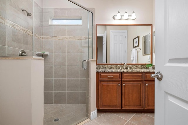 full bath featuring a stall shower, vanity, and tile patterned floors