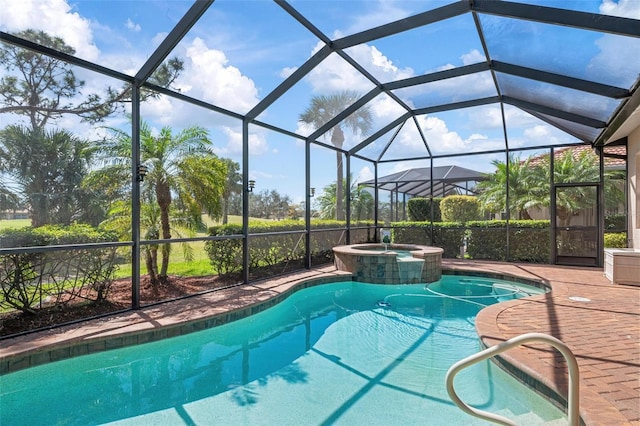 view of pool featuring glass enclosure, a patio, and a pool with connected hot tub