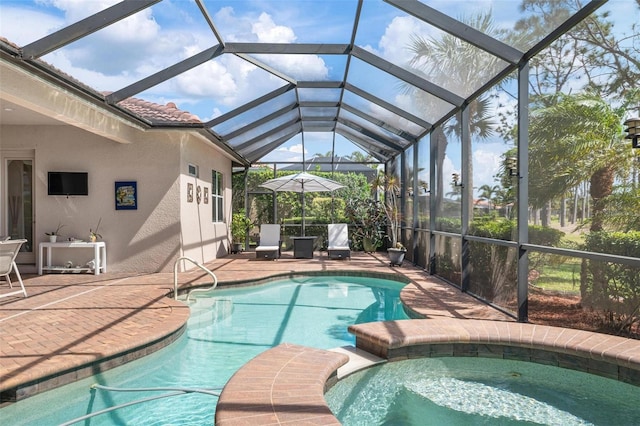 view of pool featuring a pool with connected hot tub, glass enclosure, and a patio