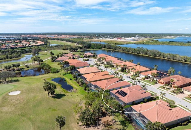 drone / aerial view featuring a residential view, view of golf course, and a water view