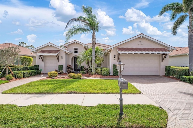 view of front of home with a garage, a tile roof, decorative driveway, and stucco siding