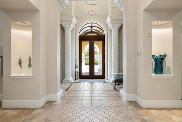 entryway with french doors, light tile patterned flooring, decorative columns, and baseboards