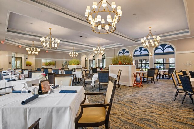 dining area with carpet floors, a chandelier, and a raised ceiling