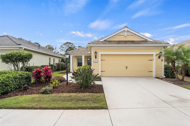 view of front of house featuring concrete driveway, a tile roof, and an attached garage