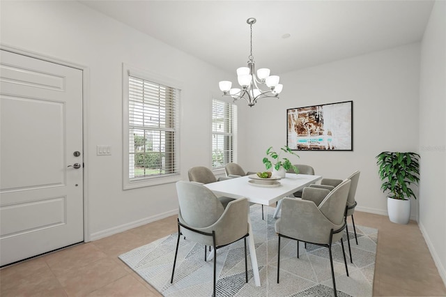 dining space with light tile patterned floors, baseboards, and a chandelier