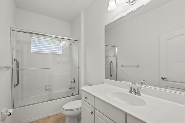 bathroom with tile patterned flooring, combined bath / shower with glass door, vanity, and toilet