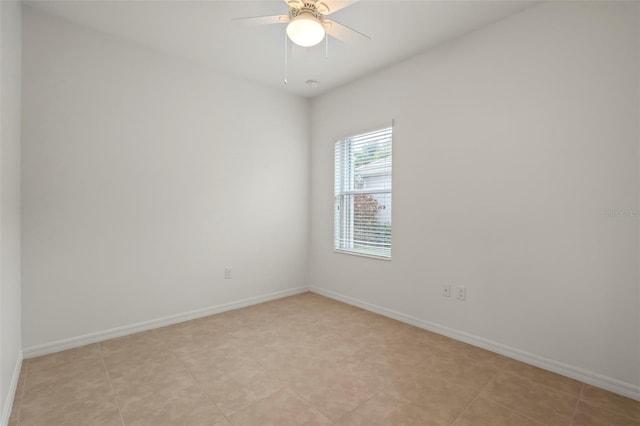 spare room with ceiling fan, light tile patterned floors, and baseboards