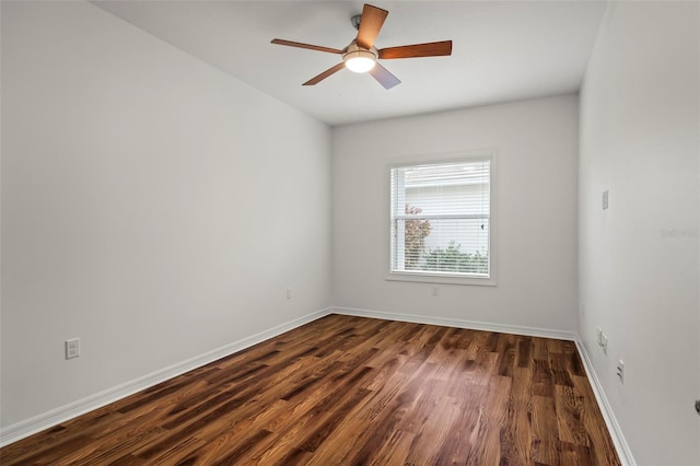 spare room with dark wood-style floors, ceiling fan, and baseboards