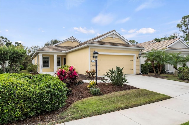 single story home featuring driveway, a tile roof, a garage, and stucco siding