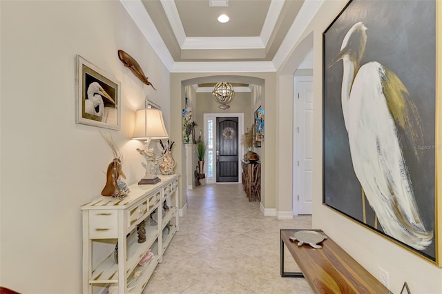 interior space featuring light tile patterned floors, a notable chandelier, baseboards, ornamental molding, and a tray ceiling