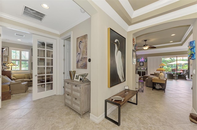 hall with light tile patterned floors, french doors, visible vents, and crown molding