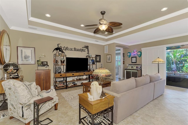 living area featuring plenty of natural light, a tray ceiling, and arched walkways