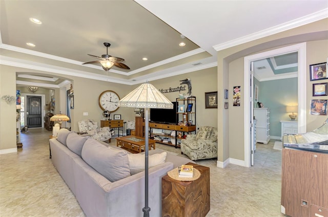 living room featuring recessed lighting, a raised ceiling, ornamental molding, ceiling fan, and baseboards