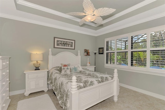 bedroom featuring ceiling fan, baseboards, a raised ceiling, and crown molding