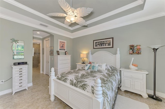 bedroom featuring baseboards, visible vents, arched walkways, a tray ceiling, and crown molding