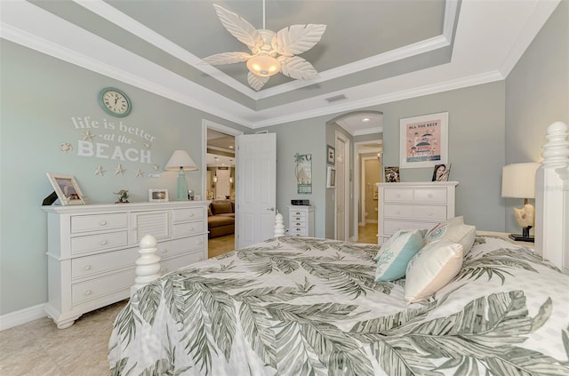 bedroom with ornamental molding, a tray ceiling, arched walkways, and visible vents