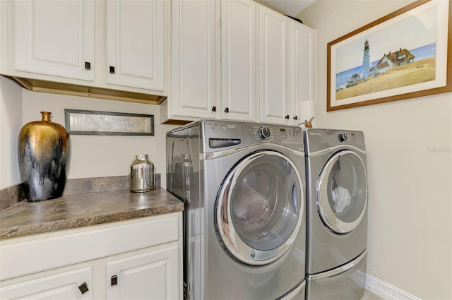 clothes washing area featuring independent washer and dryer, cabinet space, and baseboards