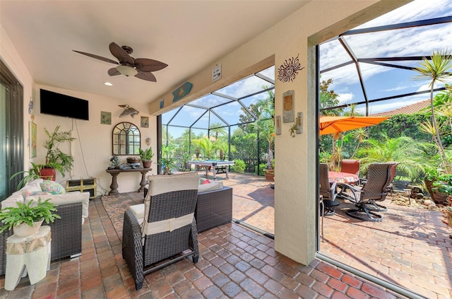 view of patio / terrace featuring a lanai, ceiling fan, an outdoor living space, and outdoor dining space