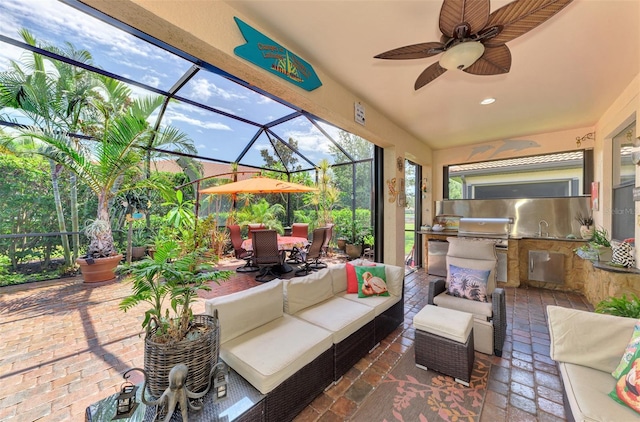 view of patio / terrace with a lanai, outdoor dining area, exterior kitchen, outdoor lounge area, and a sink