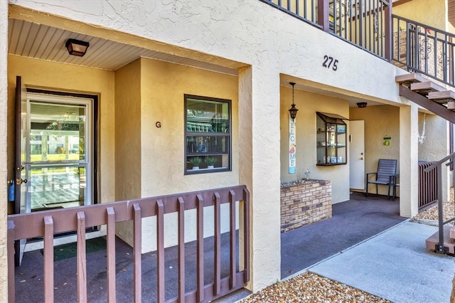 doorway to property featuring stucco siding