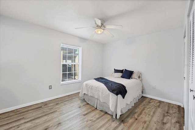 bedroom featuring wood finished floors, a ceiling fan, and baseboards