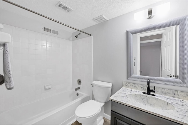 bathroom featuring toilet, visible vents, and a textured ceiling