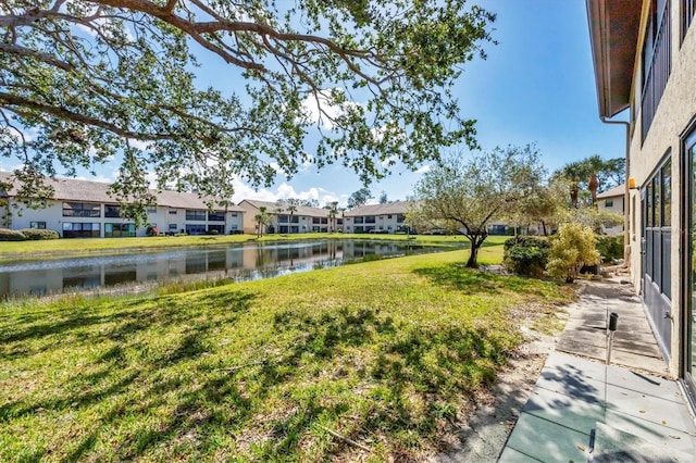 view of yard with a residential view and a water view