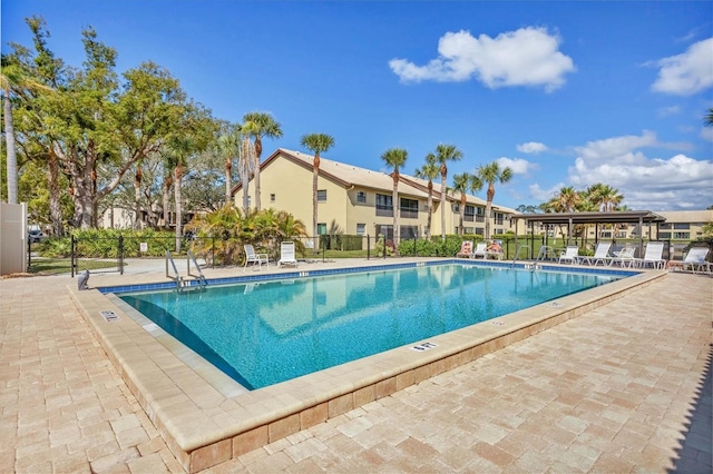 pool featuring fence and a patio