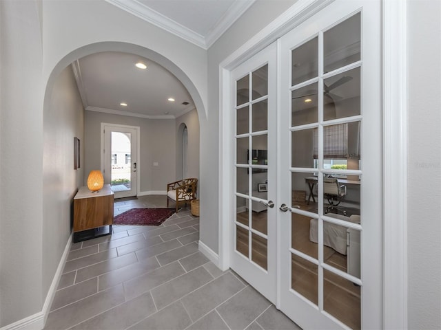 doorway with baseboards, arched walkways, tile patterned floors, crown molding, and recessed lighting