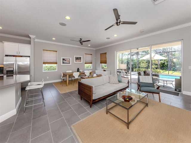 tiled living room with crown molding, baseboards, and a wealth of natural light