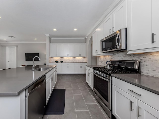 kitchen with appliances with stainless steel finishes, a sink, white cabinets, and tile patterned floors