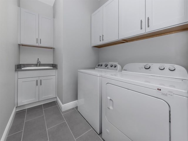 laundry area featuring cabinet space, baseboards, tile patterned floors, independent washer and dryer, and a sink