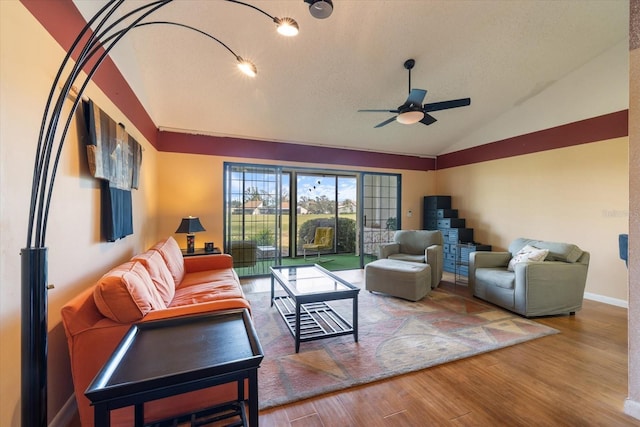 living room with baseboards, a ceiling fan, wood finished floors, vaulted ceiling, and a textured ceiling