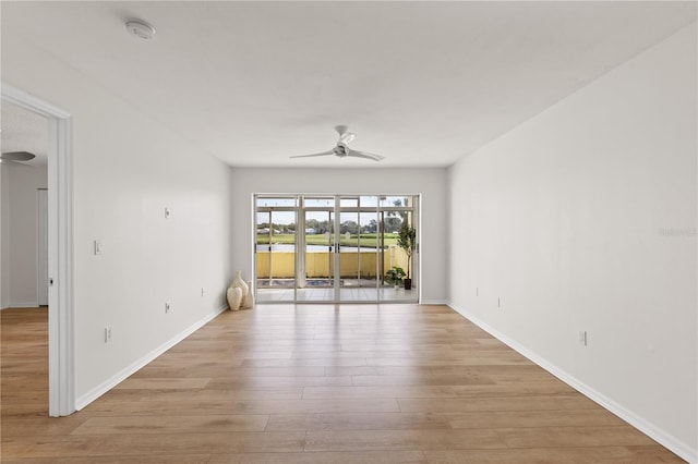 spare room featuring light wood-style flooring, baseboards, and a ceiling fan