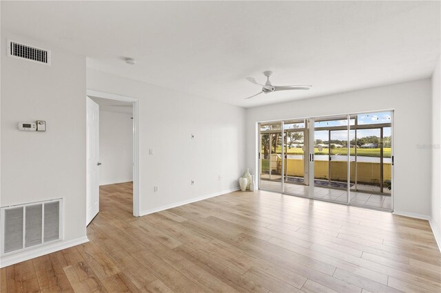 unfurnished room with light wood-type flooring, baseboards, visible vents, and a ceiling fan