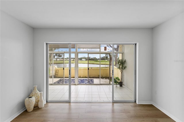 doorway featuring baseboards and wood finished floors