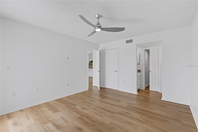 unfurnished bedroom with light wood finished floors, baseboards, visible vents, a ceiling fan, and a textured ceiling