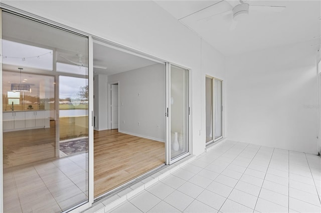 interior space with a ceiling fan and light tile patterned floors