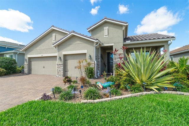 view of front of home with stone siding, a tiled roof, an attached garage, decorative driveway, and stucco siding