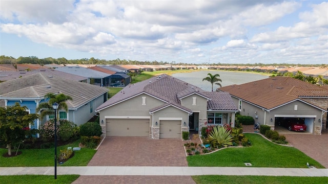 view of front of property with an attached garage, a residential view, decorative driveway, and a front yard