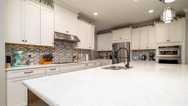 kitchen featuring decorative backsplash, stainless steel appliances, light countertops, under cabinet range hood, and a sink