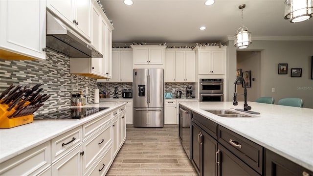 kitchen featuring under cabinet range hood, stainless steel appliances, a sink, white cabinetry, and light countertops