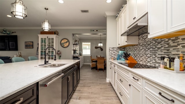 kitchen featuring wood finish floors, black electric stovetop, light countertops, a sink, and dishwasher