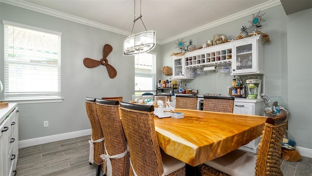 dining room featuring baseboards, ornamental molding, and wood finish floors