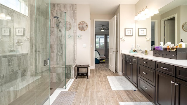 full bath with a stall shower, baseboards, connected bathroom, vanity, and wood finish floors