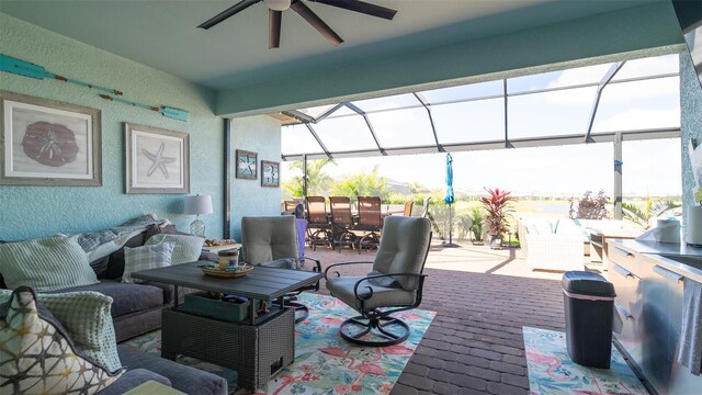 view of patio with a lanai, outdoor dining area, ceiling fan, and an outdoor living space