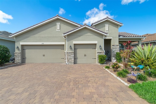 view of front of property with stone siding, decorative driveway, an attached garage, and stucco siding