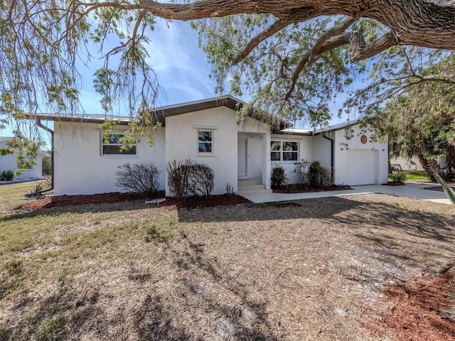 ranch-style home featuring stucco siding, driveway, and an attached garage